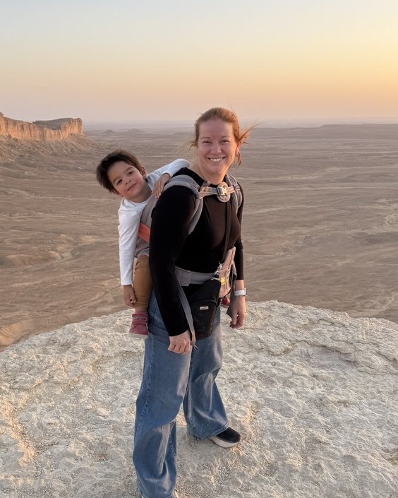 Dr. Wicoff with her son in a backpack carrier at a sunset overlook